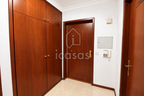 Hall de entrada com roupeiro embutido em madeira e porta de entrada