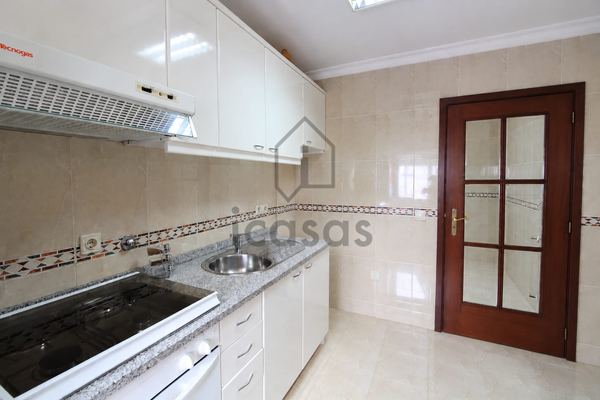 Cozinha com placa, forno, exaustor e porta envidraçada