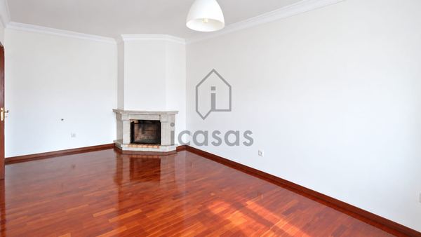 Sala vazia com lareira de canto em pedra e soalho de madeira encerado